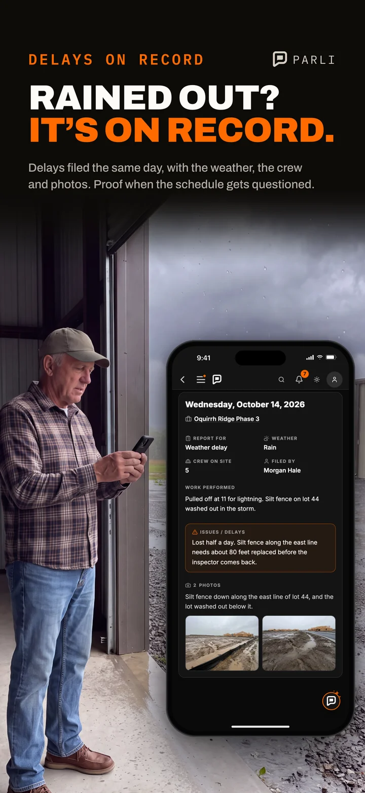 A company owner in his shop doorway on a rainy day reads a weather delay report in Parli