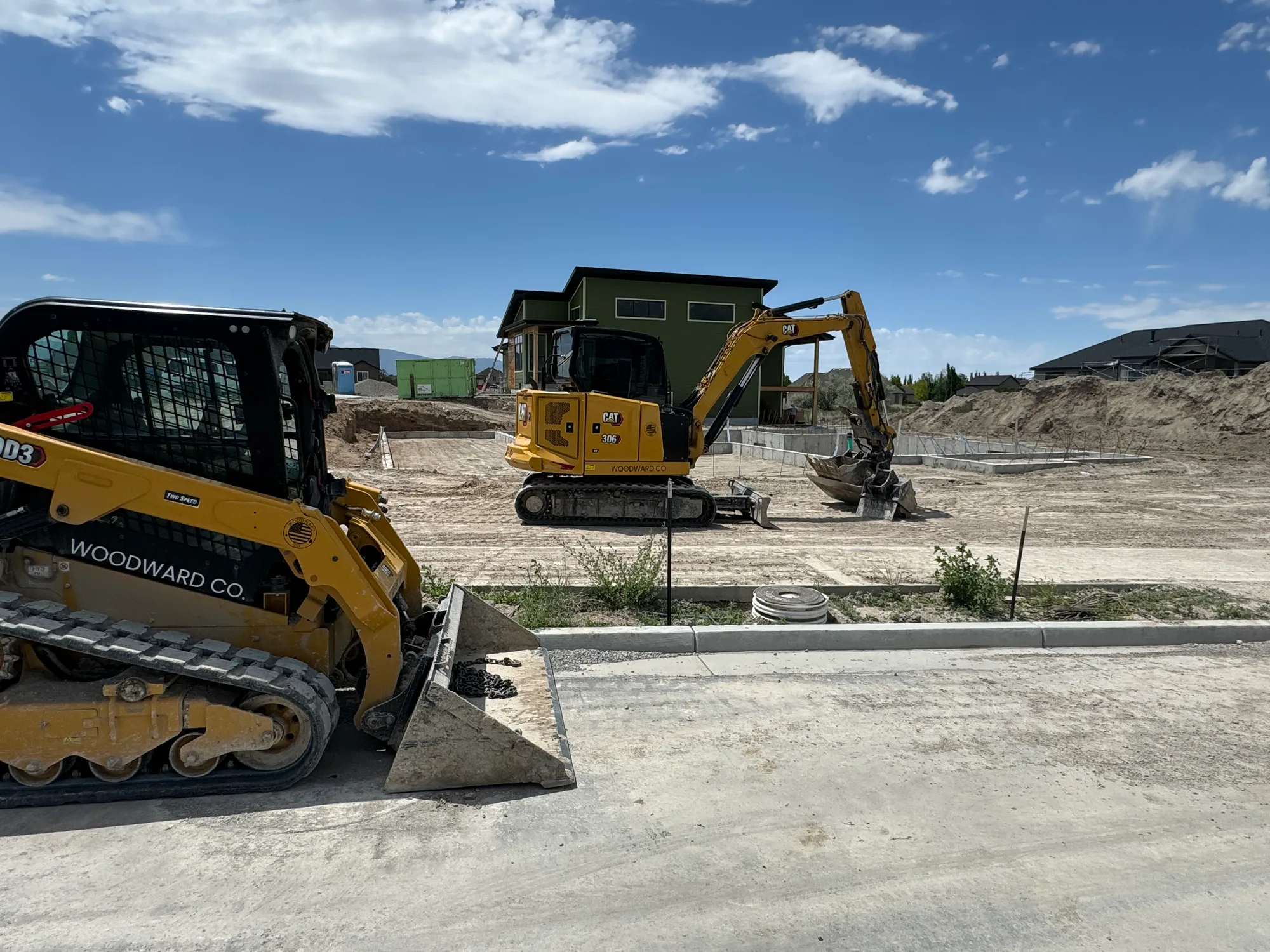 A track loader and mini excavator on a new-home lot