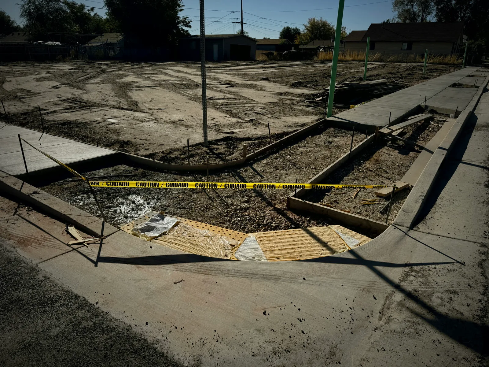 New curb and sidewalk forms behind caution tape